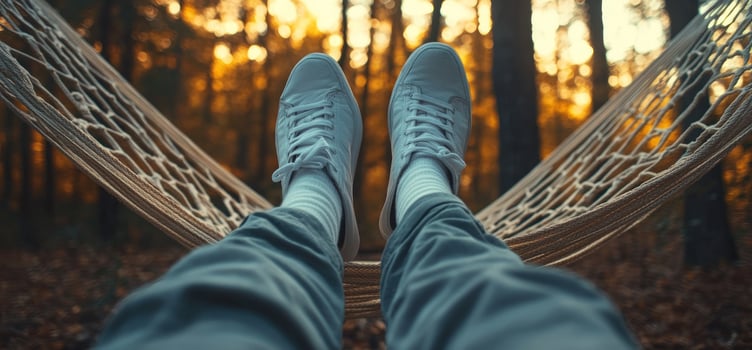 Person relaxing in a hammock in the woods. photo