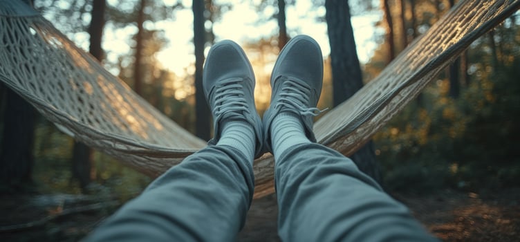 Relaxing in a hammock in the woods, with feet up. photo
