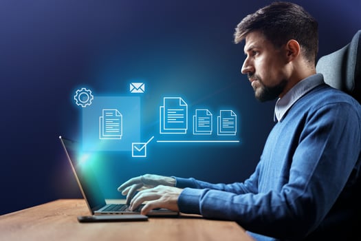 Young professional working on a laptop in a modern office displaying digital icons related to productivity and efficiency photo