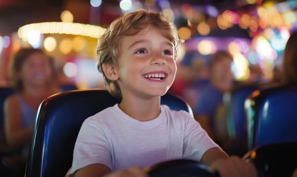 Smiling boy enjoying a ride at an amusement park. photo