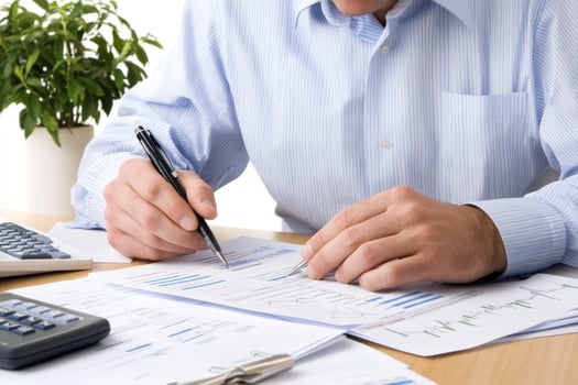 A businessman working on financial documents at a desk. photo