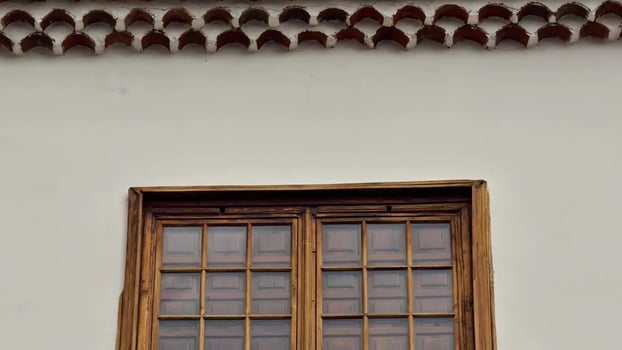 A window with a wooden frame and a clock on it photo