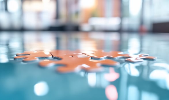 Three puzzle pieces lie on a reflective surface, symbolizing teamwork, connection, and problemsolving. photo