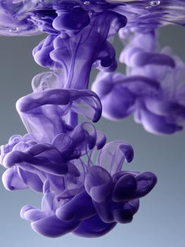 A purple liquid is floating in water photo