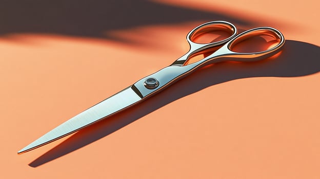 Shiny silver scissors on peach background. photo