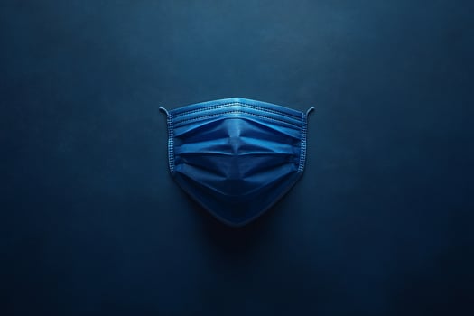 Blue surgical mask on dark blue background. photo