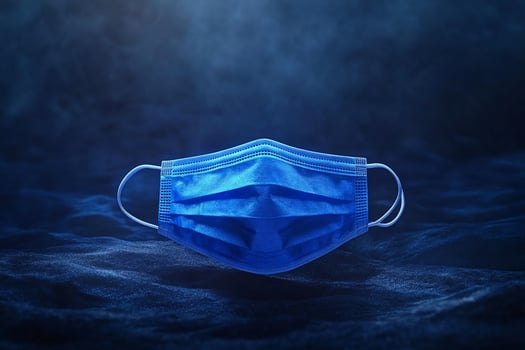 Blue surgical mask on dark blue surface. photo