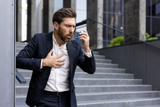 Man with inhaler on urban stairs photo