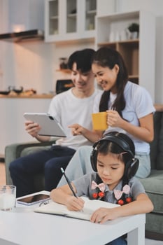 Family together at home with child studying photo