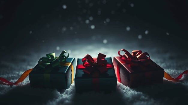 Three presents sitting on a snow covered surface photo