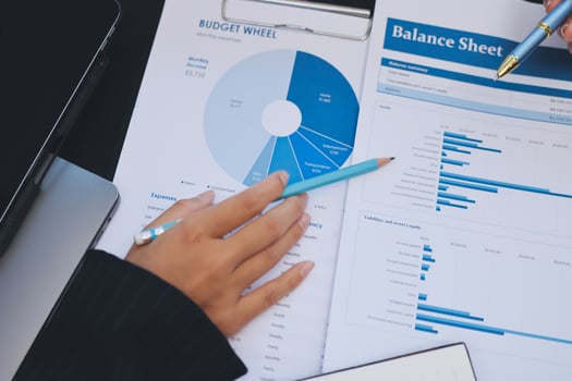 Hand analyzing financial documents on table photo