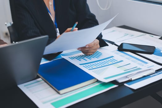 Hands reviewing documents with charts photo