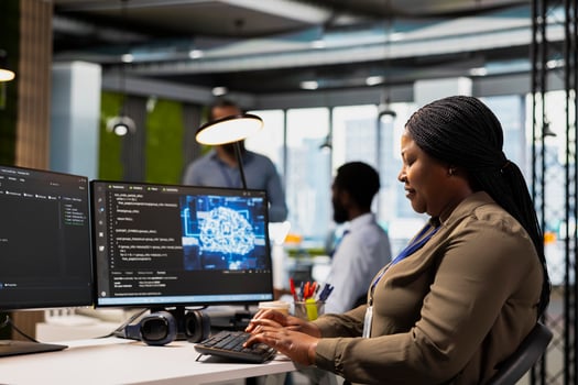 System administrator in office using AI automation scripts to reduce repetitive coding tasks. Woman using artificial intelligence technology on PC in high tech startup workspace photo