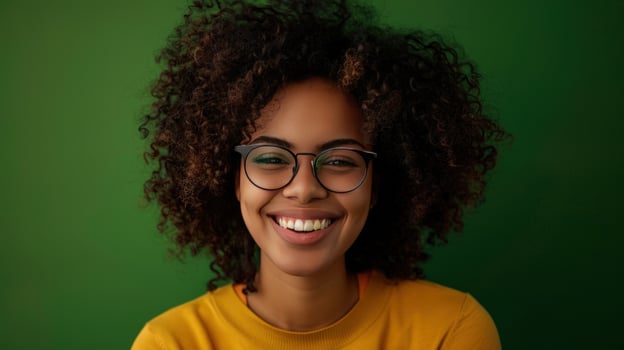 Joyful young adult smiling portrait with eyeglasses on green background photo