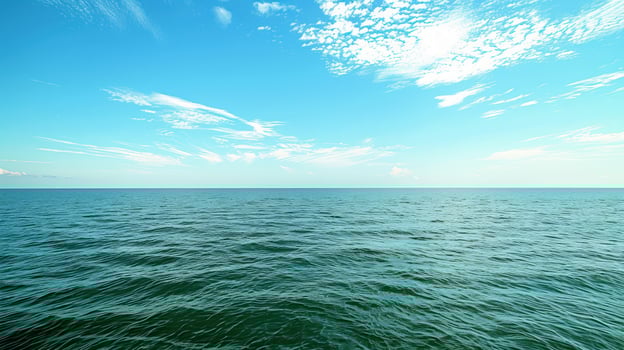 Serene ocean view under blue sky with white clouds water horizon and ripples photo