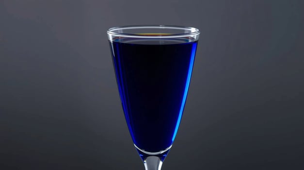 A blue liquid in a glass on a black background photo