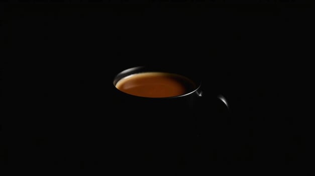 A cup of coffee is shown in the dark photo