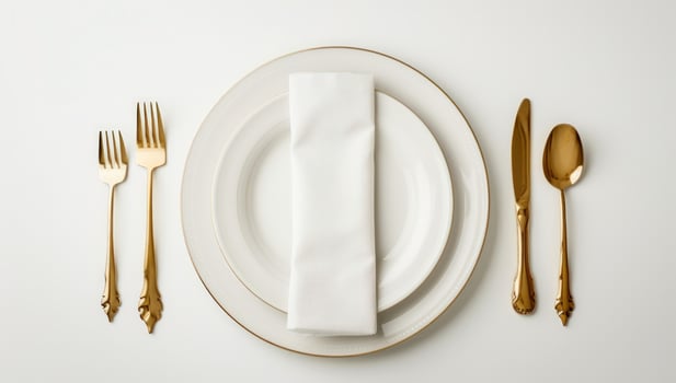 Elegant table setting featuring gold cutlery and crisp white linen on plates photo