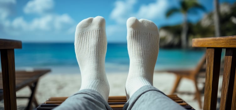 Relaxed feet in white socks on beach chair, ocean view. photo