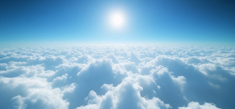 Aerial view of vast, fluffy cumulus clouds under a bright sun and clear blue sky. photo