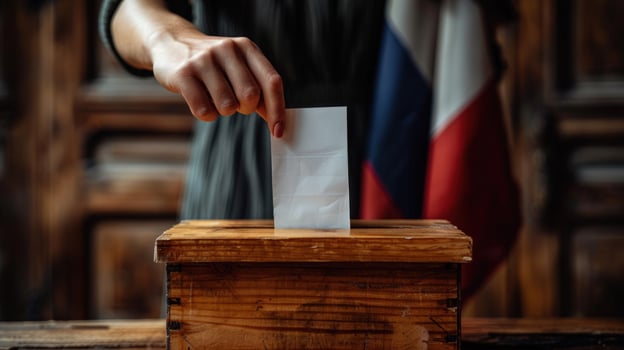 Ballot box voting hand inserting paper in wood container with flag for elections photo