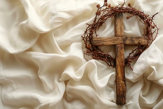 Wooden cross with thorns on cream fabric symbolic religious still life background photo