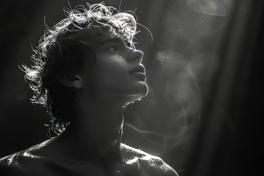 Person looking up in striking black and white portrait with light and water photo