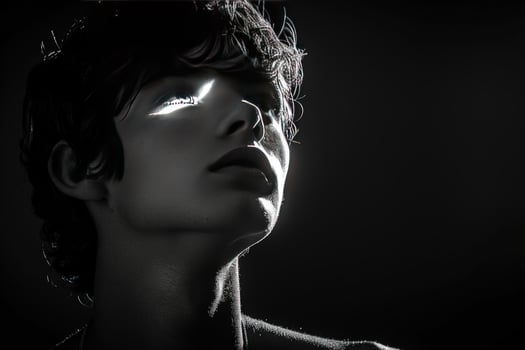 Dramatic portrait of face with strong light and shadow in black and white photo