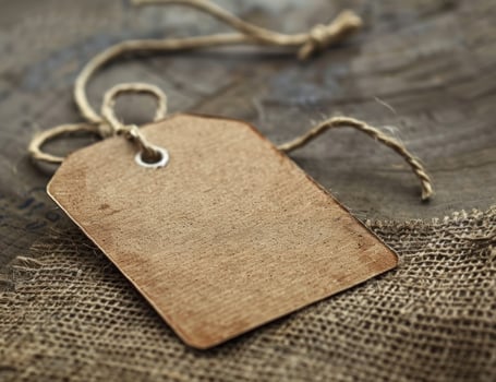 Blank cardboard tag on burlap and wood background for mockup and display photo