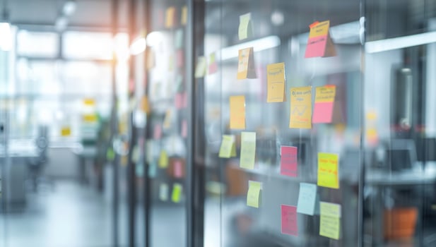 Creative brainstorming glass wall covered with colorful sticky notes in modern office photo