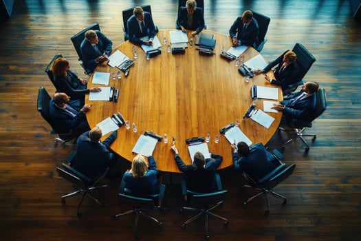 Business people sitting around a round table in a meeting room photo