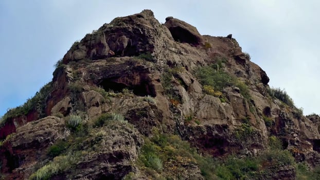 A Majestic Rocky Cliff adorned with Lush Vegetation and surrounded by a captivating landscape photo