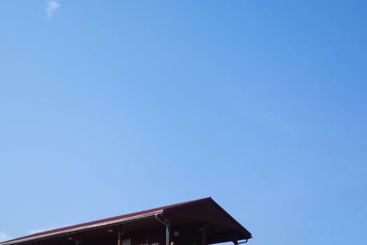 Bright blue sky above a rural building with a red roof during daytime photo