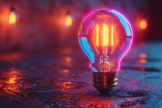 A single glowing light bulb with a pink and blue neon glow in the background. photo