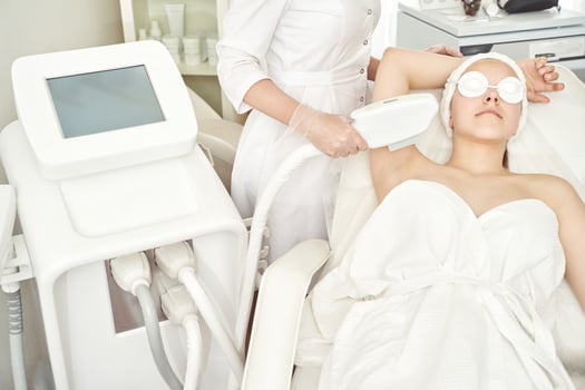 Young caucasian female receiving laser hair removal treatment in modern medical clinic. photo