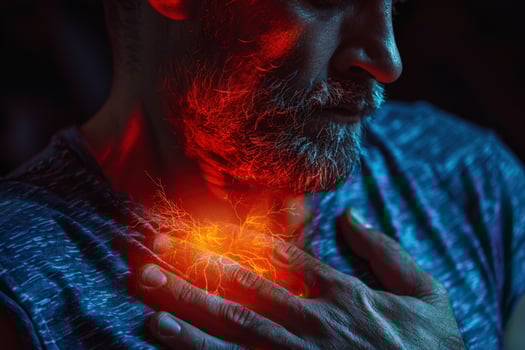 Man suffering from chest pain, with a red glowing effect, clutching his chest. photo