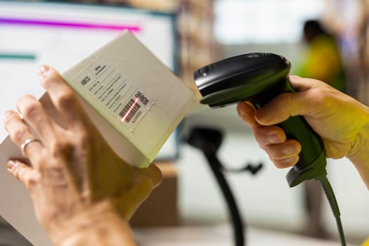Close up of worker manages cargo barcode scanning in a distribution hub, preparing the goods with packaging, tagging and inventory checking. Man using a scanner in fulfillment center. photo