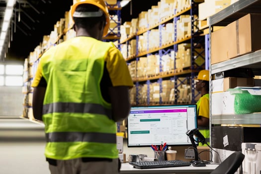Warehouse worker focusing on supply chain logistics with tracking software, managing shipping labels for e-commerce orders. Man organizing items for shipping and ensuring inventory check. photo