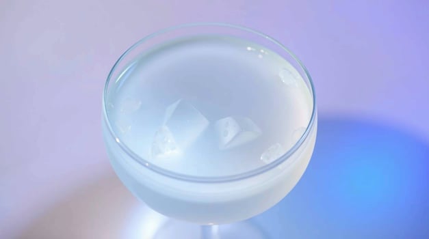 A glass of white liquid with ice cubes photo