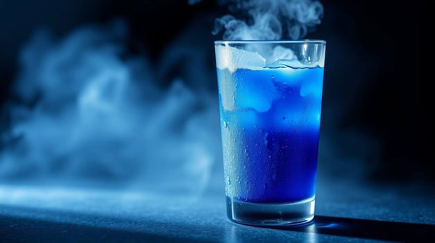 Blue drink in a glass with smoke coming out photo