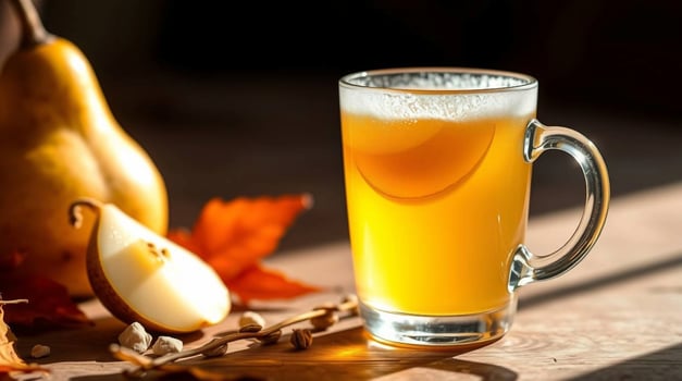A glass of cider with pears and leaves photo