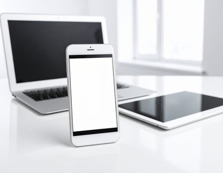 White laptop, smartphone and tablet on white table photo