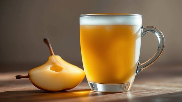 A glass of beer and a pear on a table photo