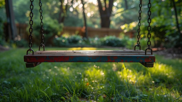 A wooden swing set in a backyard with green grass and a blurred background of trees. photo