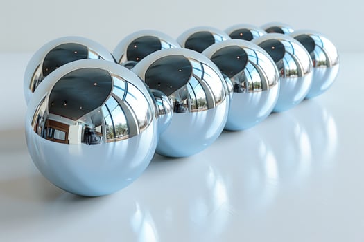 A row of shiny, silver spheres reflecting the surrounding environment on a white background. photo