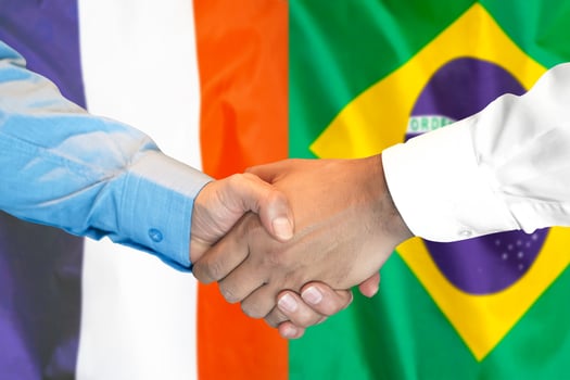 handshake on France and Brazil flag background. photo
