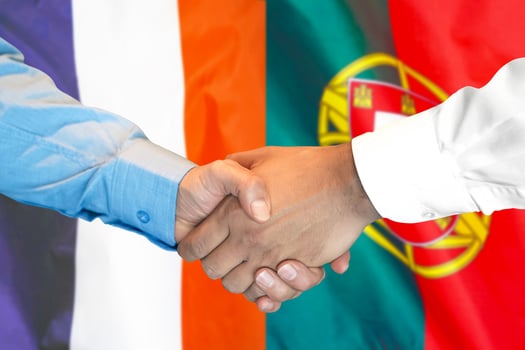 handshake on France and Portugal flag background. photo