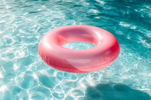 Pink inflatable pool float drifting in clear blue water photo