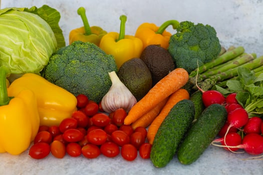 Selection of colorful fresh vegetables, including broccoli, yellow bell peppers, cabbage, carrots, radishes, cucumbers, cherry tomatoes, asparagus, avocado and garlic. Healthy and natural produce photo