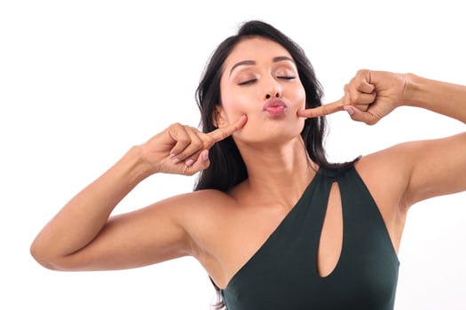 Young Woman Pointing Her Fingers At Her Cheeks photo